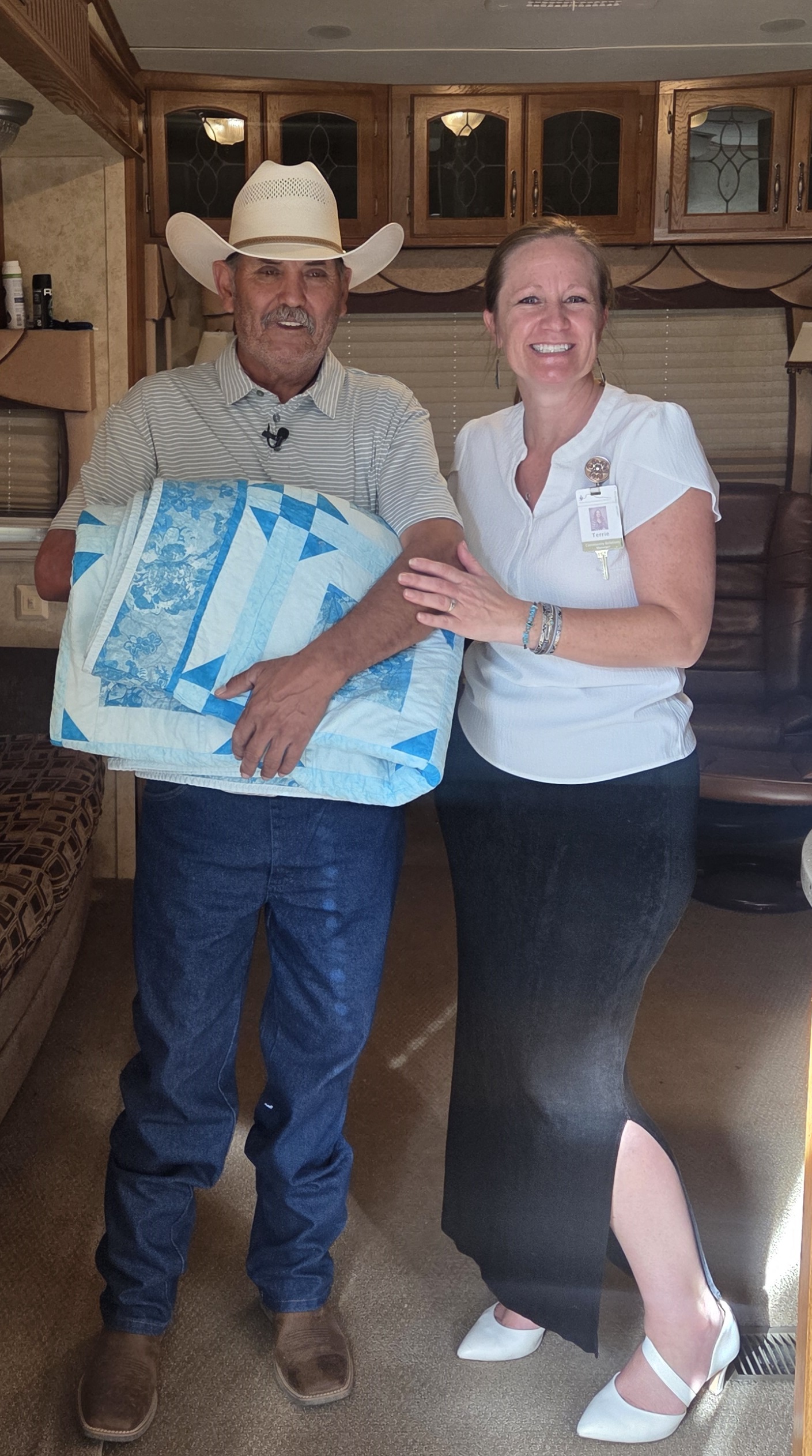 Terrie Davidson, WCH, presenting Manuel Gomez with his new quilt from Vulture Peak Patchers Quilt Guild in his new mobile home!